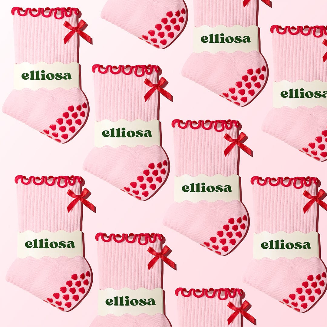 Pattern of pink socks with red hearts and bows, branded 'elliosa', on a white background.