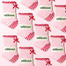 Pattern of pink socks with red hearts and bows, branded 'elliosa', on a white background.