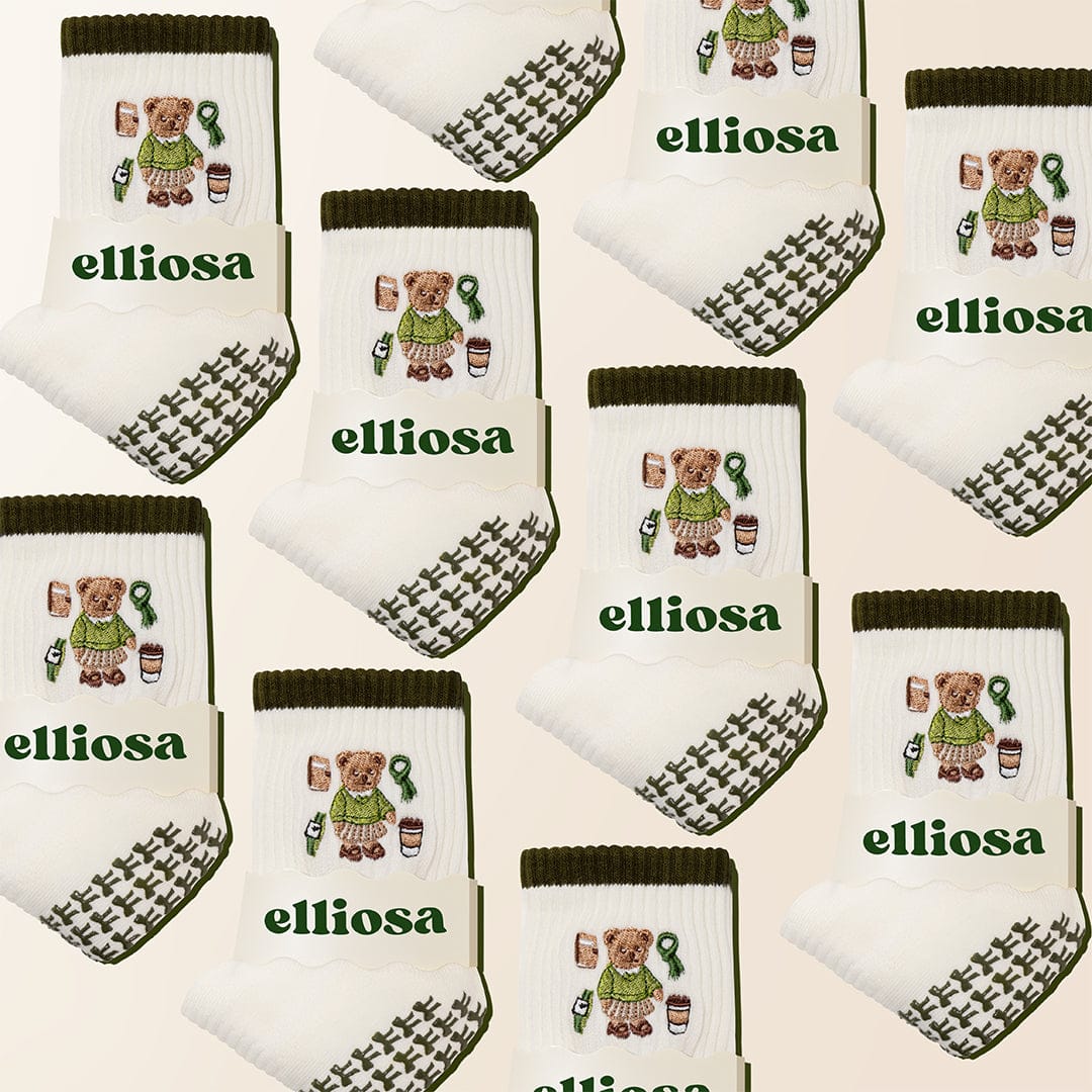 Multiple pairs of socks with teddy bear designs and 'elliosa' branding on a beige background.