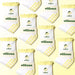 White socks with yellow frills and lemons and the word 'sunkissed' in green, with 'elliosa' branding against a light yellow background. There are yellow lemon shaped grips on the sole.