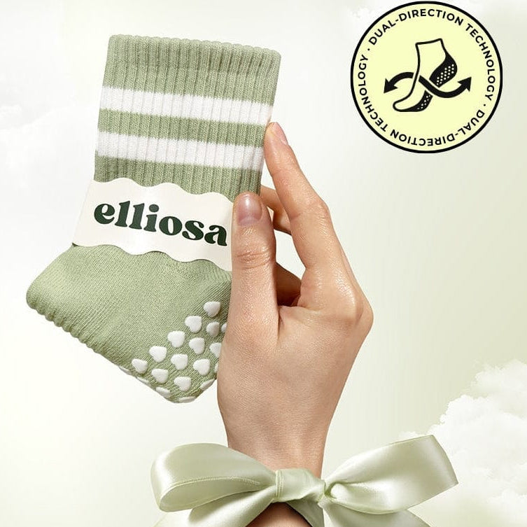 Hand holding a green sock with white stripes and 'elliosa' branding, against a light background.