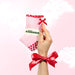 Hand holding a pink sock with a red bow, featuring the brand 'elliosa'.