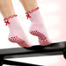 Pink socks with red bows and heart patterns on a white background