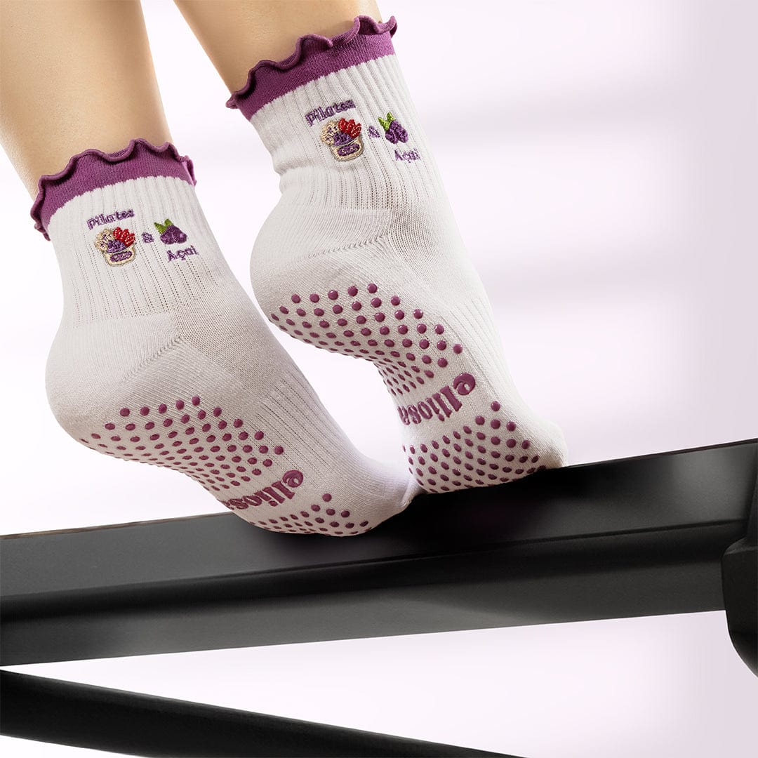 White socks with purple accents and grip dots on a white background