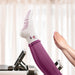 Person wearing a white sock with pink dots and purple leggings on a blurred indoor background