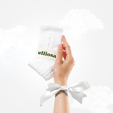 White ribbed socks with a 'elliosa' tag held by a hand against a white background