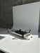 Core Collab Queen 2.0 Pilates reformer with white frame and black upholstery in a studio with white background.