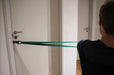 Person using the blackroll hook attached to the door, with a resistance band.