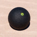 Black blackroll massage ball on the sand.