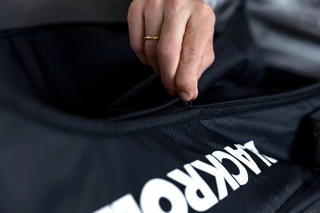 Close up of a person opening the zip of a Blackroll compression boots bag.