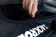 Close up of a person opening the zip of a Blackroll compression boots bag.