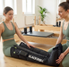 Two women in green athletic wear in a Pilates studio, one wearing Blackroll compression boots.