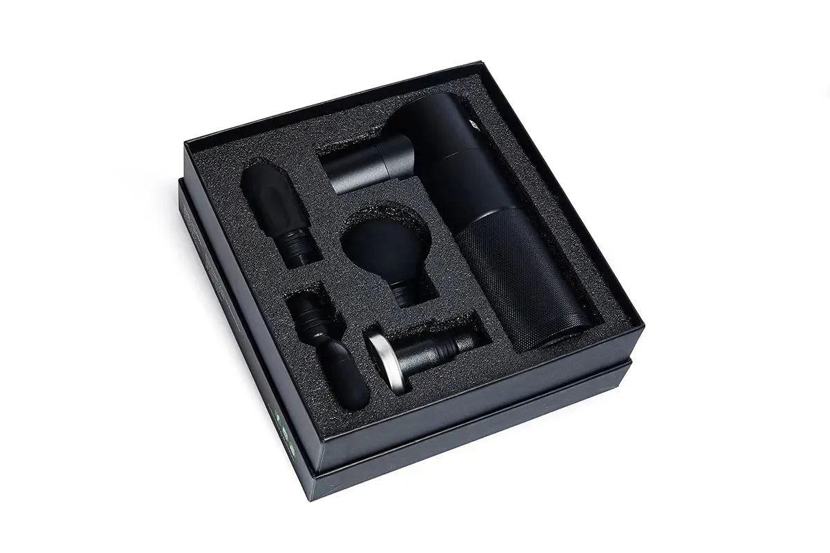 Blackroll fascia massage gun inside box with attachments surrounded by black foam.