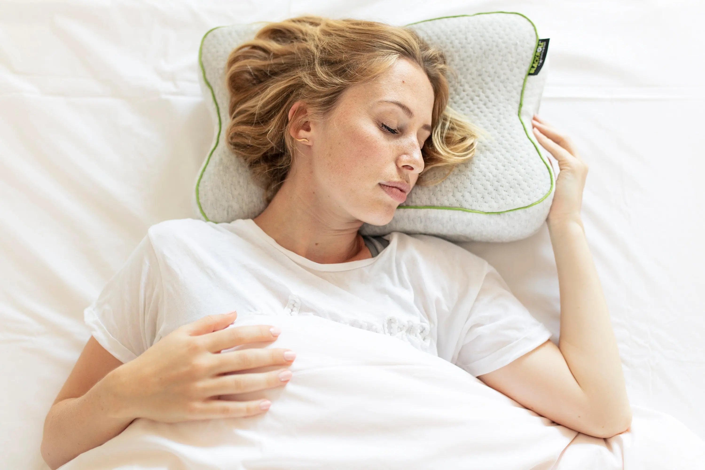 A woman sleeping comfortably using a blackroll pillow.