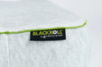 Close up of the Blackroll recovery pillow showing white pillowcase with green border and the Blackroll tag.