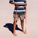 Person using an orange Blackroll superband resistance band on the sand.