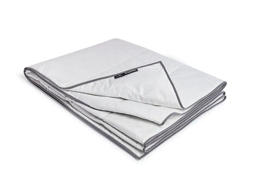 Blackroll ultralite blanket folded with the corner turned up showing the Blackroll label. 
