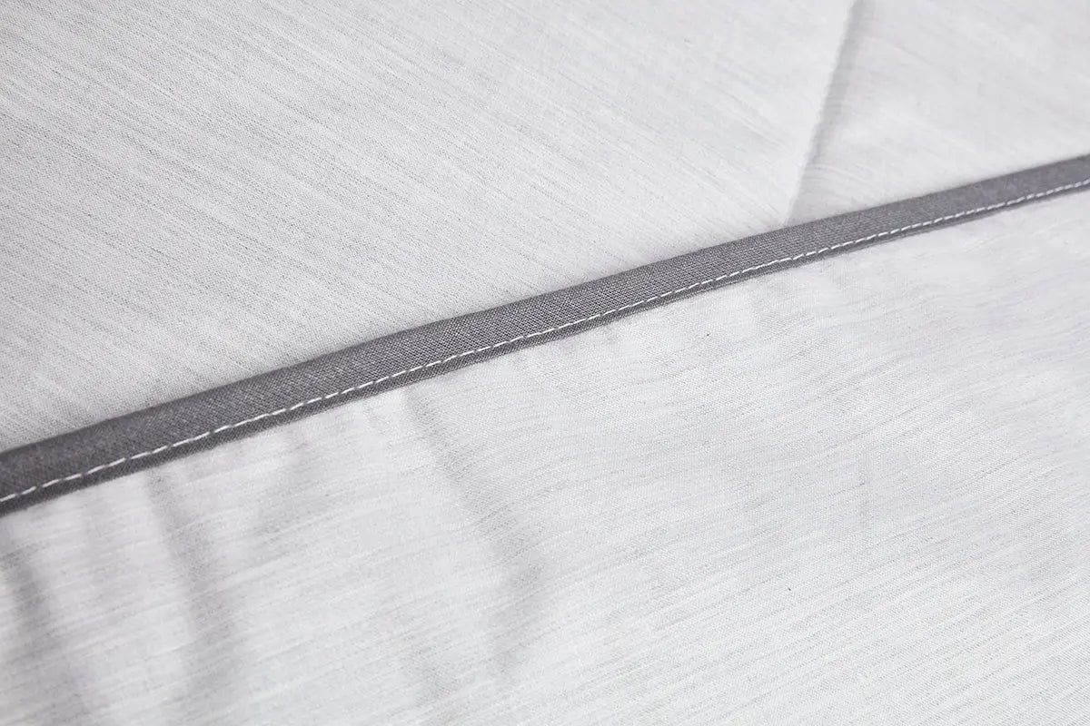 Close up of grey coloured Blackroll ultralite blanket showing grey border and white stitching.