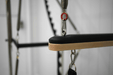 Close up of wooden bar attachment on queen reformer full trapeze with red spring showing.