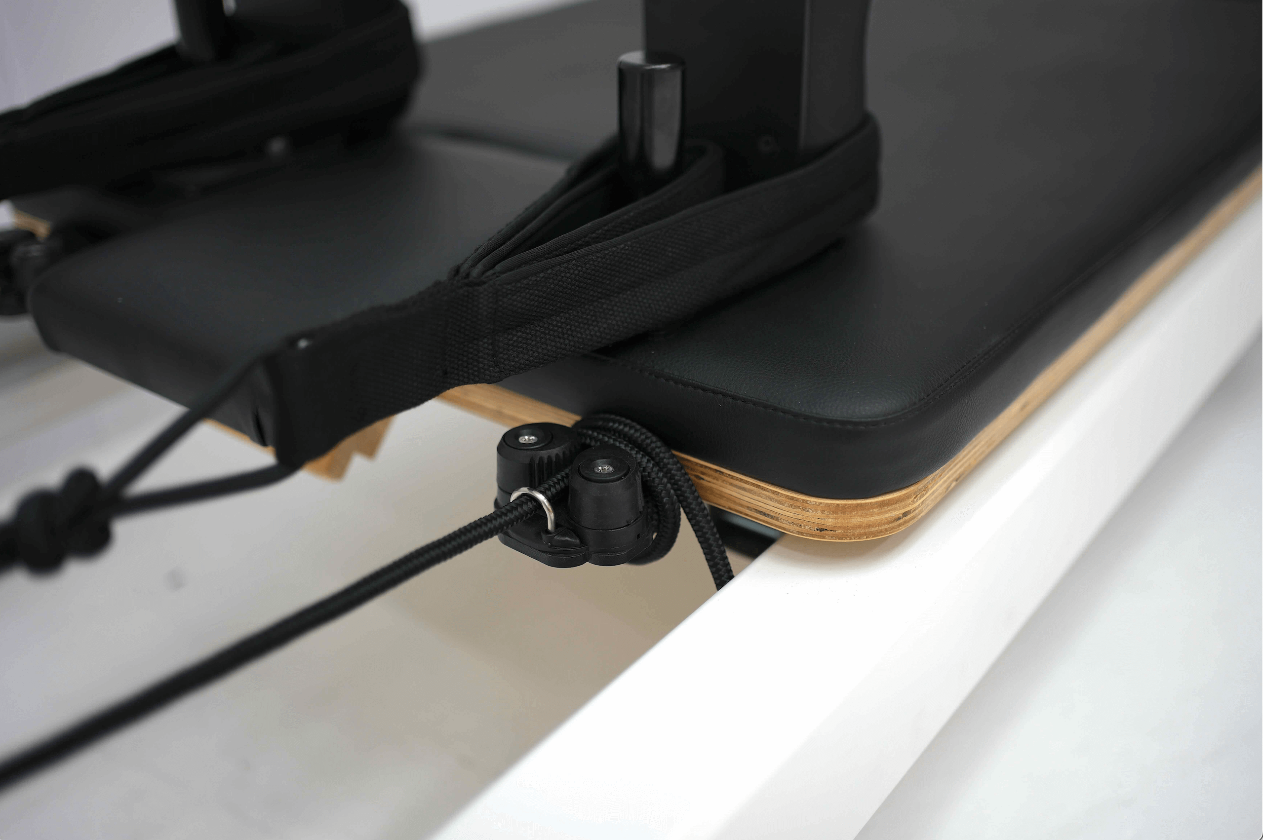 Close up on straps on the Queen reformer full trapeze, showing the head rest and shoulder pads.