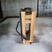 The Core Collab Foldable Eco Pilates reformer folded and standing on it's end, showing  a small footprint.