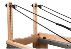 Close up end view of the Core Collab Eco Studio Full Track Pilates reformer showing the pulleys.