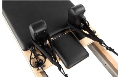 Close up of the Core Collab Eco Studio Full track Pilates reformer showing the head and shoulder rests, cleats and straps.