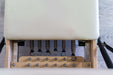 Close up view of the springs of a Core Collab Foldable Eco Pilates reformer showing 3 red, 2 green and 1 yellow spring.