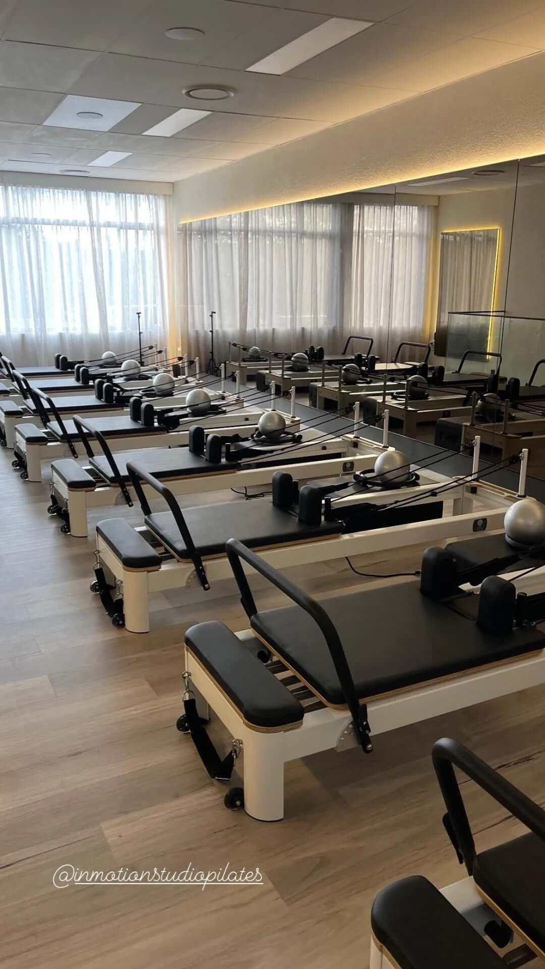 A reformer Pilates studio fitted with the Core Collab Queen Studio reformers in white with black upholstery.