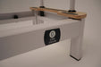 close up of the core Collab Queen Studio Pilates reformer showing the black core collab logo plate on the white frame.