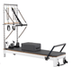 The Core Collab Queen reformer tower in white with charcoal upholstery on a white background.