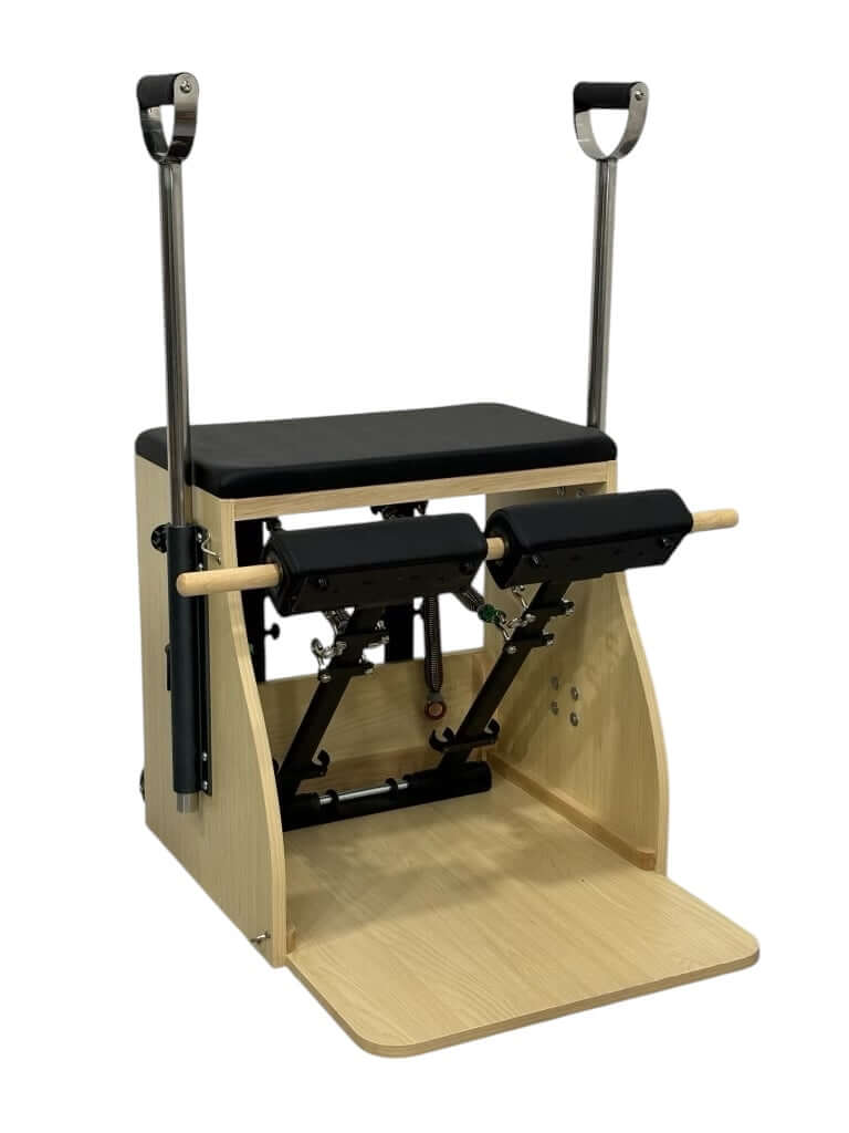 Pilates Wunda Chair by Core Collab showing dual foot pedal with two handles and black upholstery.