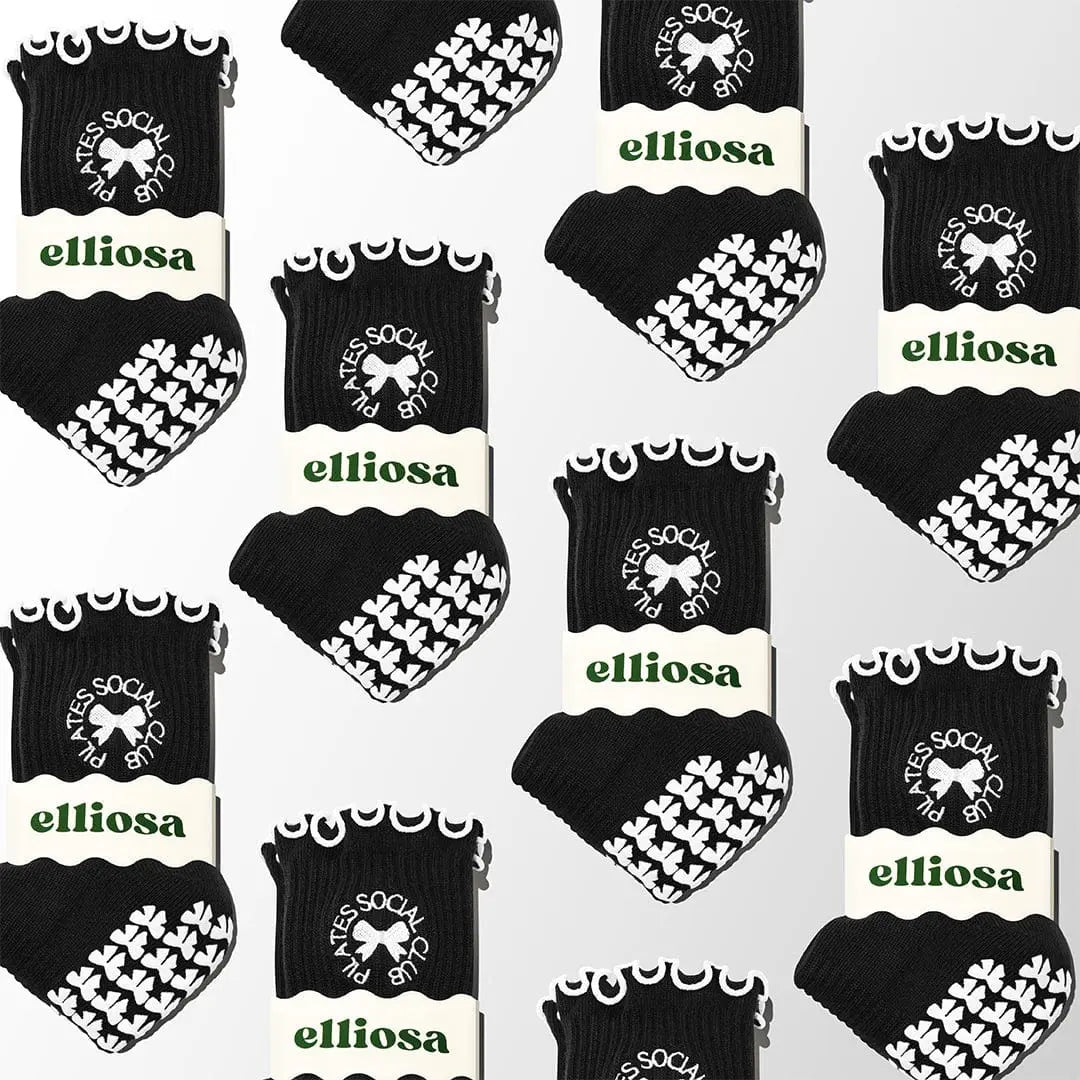 Pattern of black and white Elliosa dual direction grip socks with 'Elliosa' branding on a white background in Pilates social club design.