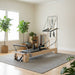 Pilates reformer with half trapeze attachment in a studio set up with a grey rug and greenery.