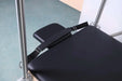 Close up of head rest of cadillac table with black upholstery and straps.