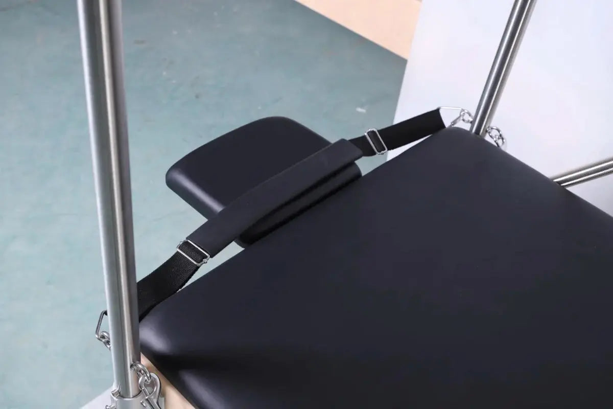 Close up of head rest of cadillac table with black upholstery and straps.