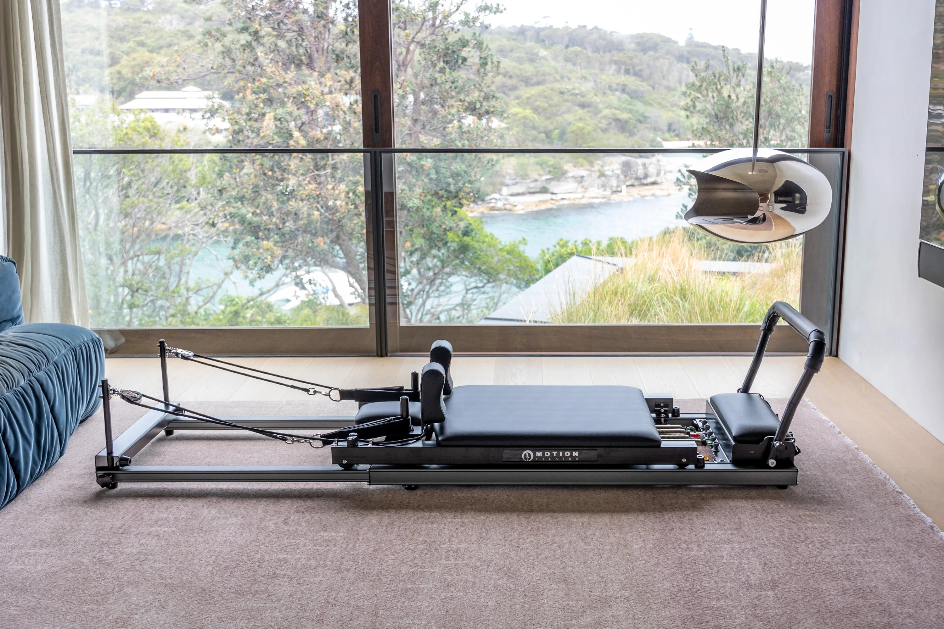 sleek black pilates reformer on the floor of a bedroom
