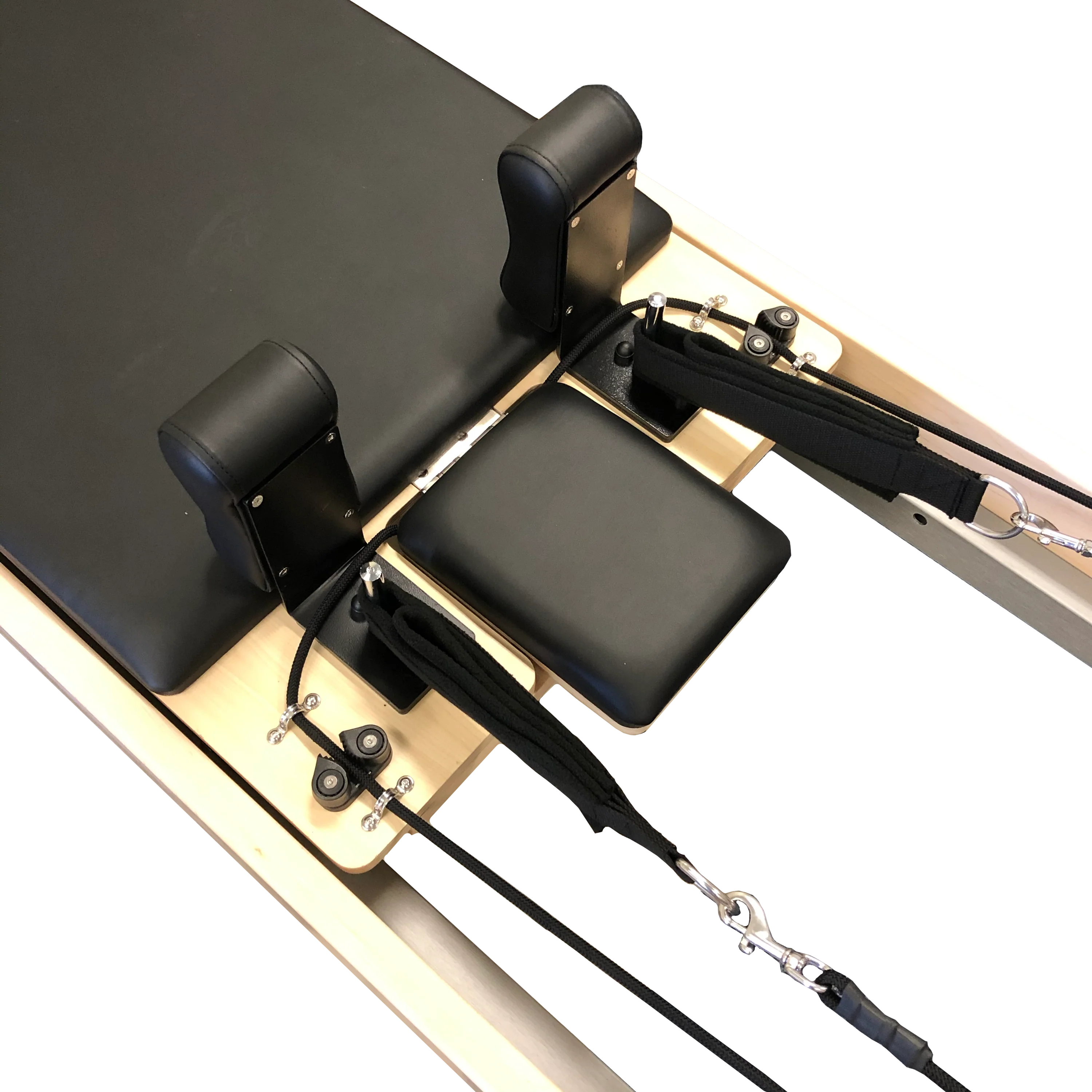 Close up of reformer pilates machine showing black head and shoulder cushions.