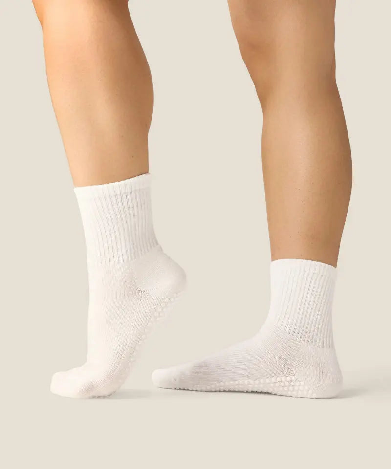 White crew grip socks above ankles with white grips on walking feet.