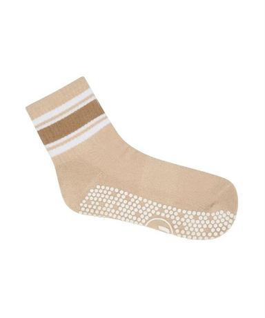 Beige sock with white stripes and grips on the sole on a white background.