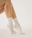 White crew grip socks above ankles with white grips on pointed toes.