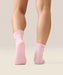Rear view of pink moveactive heart ruffle socks with grips and logo visible on sole.