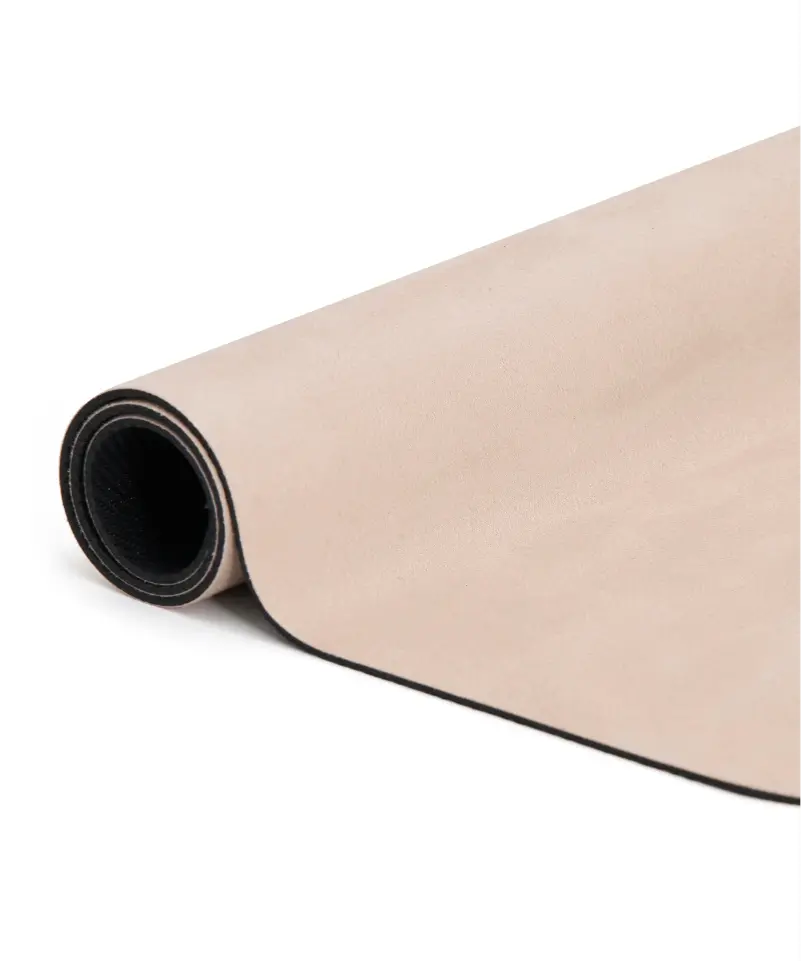 Close up view of a rolled up almond coloured microfibre reformer mat.