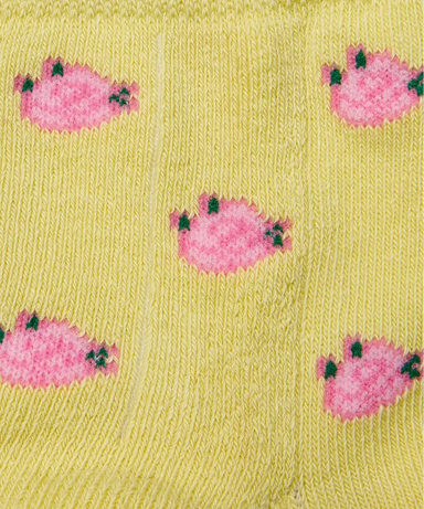 Close up of yellow grip socks with small pink flowers.