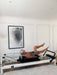 Woman exercising on the Core Collab Queen studio Pilates reformer in a living room setting.