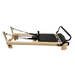 Light coloured wooden pilates reformer with black upholstery and steel track running the entire length of the reformer. 