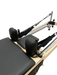 Close up view of pilates reformer with black head and shoulder cushions.