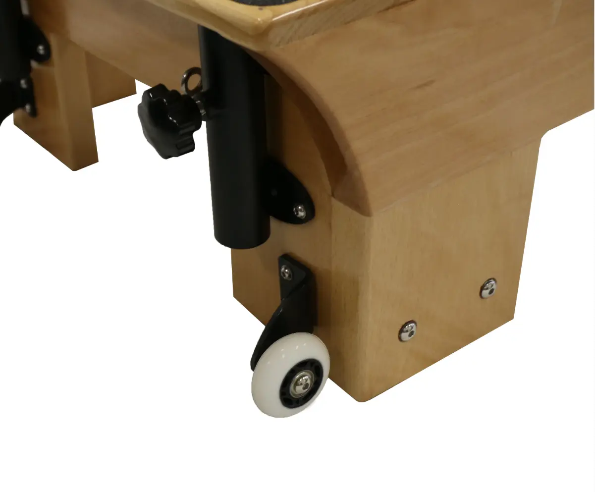 Close up of the feet of a pilates reformer with white wheels.