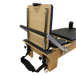 close up of foot end of wooden reformer pilates machine showing white wheels, adjustable footbar and jump board attachment.