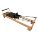 light coloured wooden pilates reformer with black upholstery and adjustable foot bar.